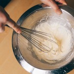 Tarte Tropézienne – Battre au fouet les jaunes d'oeuf. (Photo : Elodie Davis).