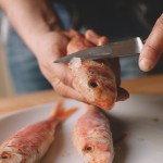 Salade de rougets - Enlever les écailles du rouget en grattant la peau avec le dos d’un couteau. (Photo : Elodie Davis).