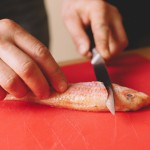 Salade de rougets - Placer le couteau derrière les branchies et découper vers le bas avec un angle légèrement en diagonale. (Photo : Elodie Davis).