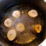 Frites de banane plantain - A l'aide d’une écumoire, déposer délicatement chaque tronçon dans l’huile de friture à la verticale.