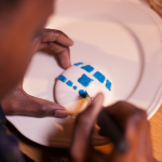 Macarons R2-D2 - Décorer la coque supérieure avec la poche contenant le glaçage bleu pour figurer les détails de R2-D2. (Photo : Elodie Davis).