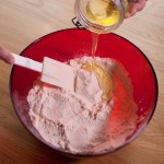 Macarons R2-D2 - Verser sur le mélange poudre d'amande-sucre glace la moitié des blancs d'œufs et le colorant alimentaire blanc. (Photo : Elodie Davis).