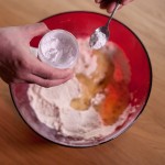 Macarons R2-D2 - Verser sur le mélange poudre d'amande-sucre glace la moitié des blancs d'œufs et le colorant alimentaire blanc. (Photo : Elodie Davis).