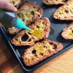 Bruschetta aux saveurs italiennes - Verser un filet d'huile d'olive sur les croûtons.