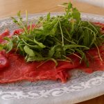 Carpaccio de bœuf à l’italienne - Disposer la roquette par-dessus et l'assaisonner avec l'huile et le jus de citron. Saler et poivrer