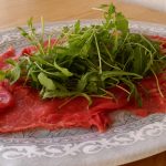 Carpaccio de bœuf à l’italienne - Disposer la roquette par-dessus et l'assaisonner avec l'huile et le jus de citron. Saler et poivrer