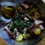 Salade de poulpe de roche - Verser sur le saladier les herbes, l’huile d’olive, le jus de citron, l’ail pressé, le shichimi togarashi et les olives taggiasche.