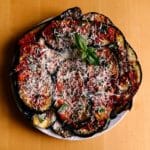 Aubergines à la sicilienne - Étaler une c. à café de sauce dans chaque aubergine, parsemer de basilic, saupoudrer de pecorino. Répéter l’opération en alternant les couches d’aubergine dans la même assiette.